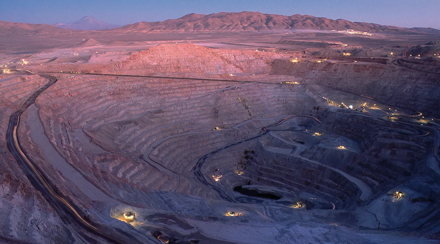 Terraced open-pit mine surrounded by desert mountains
